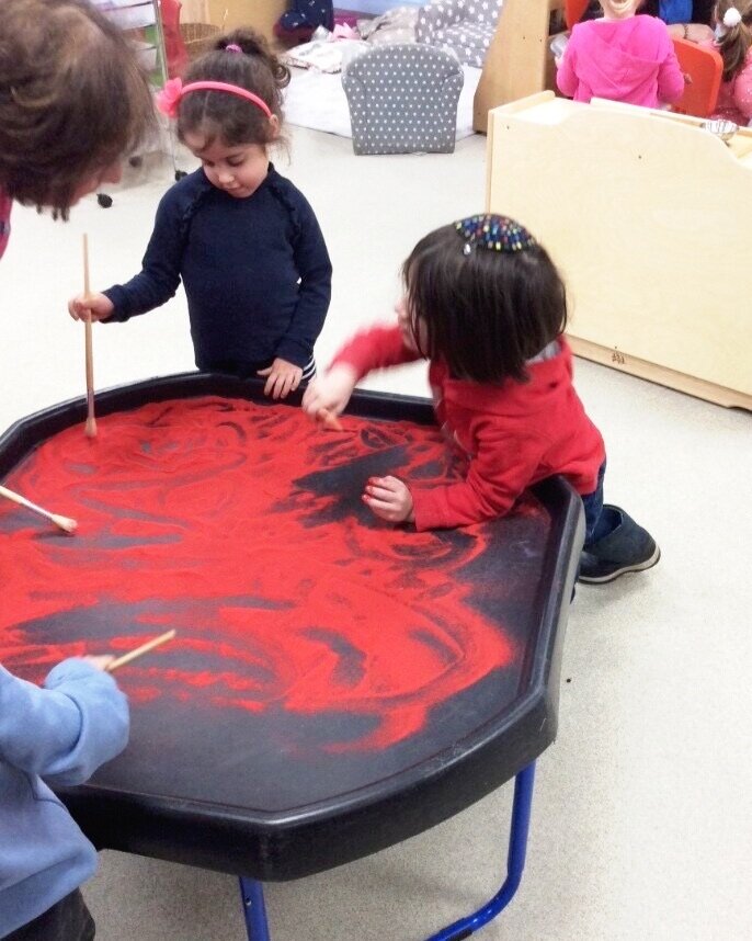 A jewish boy and girl playing with sand at woodside gan